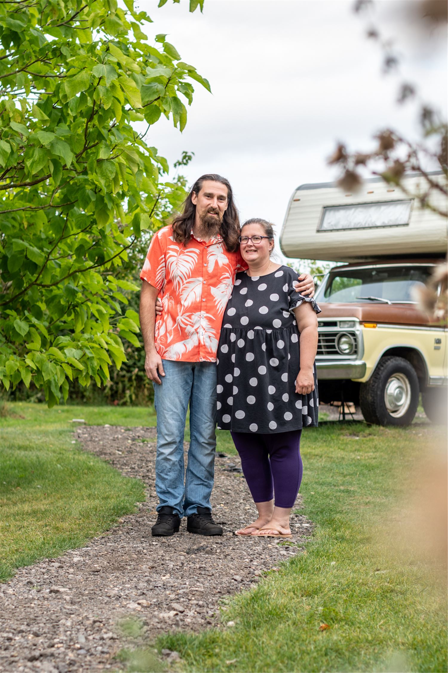 A man and woman standing in front of a truck.